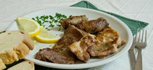 a plate of food with chicken and bread and a lemon at Agriturismo Tenuta Margitello in Comiso