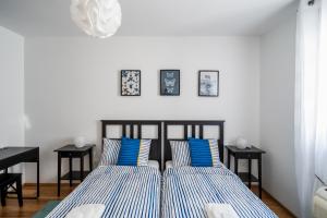 sypialnia z dwoma łóżkami z niebieskimi i białymi poduszkami w obiekcie Downtown Apartment Helena w mieście Opatija
