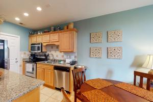 a kitchen with wooden cabinets and a table with a dining room at Shipwatch 2173 in Kiawah Island