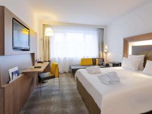 een hotelkamer met een groot bed en een bureau bij Novotel Hannover in Hannover