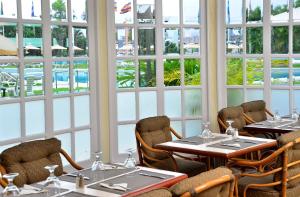 a restaurant with tables and chairs and large windows at Hotel Tamanaco Caracas in Caracas