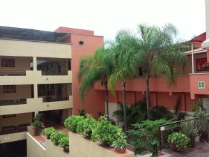 un edificio de apartamentos con palmeras en un patio en Hotel La Iguana, en Cuernavaca