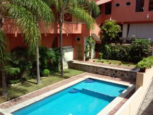 una piscina frente a un edificio en Hotel La Iguana en Cuernavaca