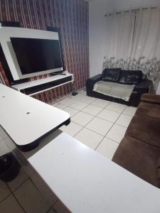 ein Wohnzimmer mit einem Sofa und einem Flachbild-TV in der Unterkunft Apartamento cabo frio familiar, bem localizado e mobiliado in Cabo Frio