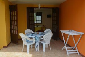 a dining room with a table and white chairs at RESIDENCE DE VACANCES MON REFUGE - BUNGALOW DE TYPE T3 in Grande Anse