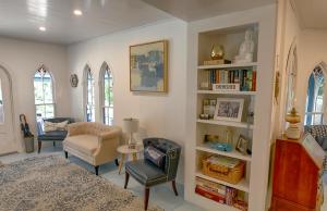 a bedroom with a bed and a chair and bookshelves at Narragansett House in Oak Bluffs
