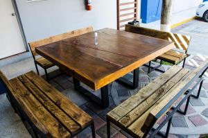 a wooden table and benches sitting next to a building at Hotel Tecnologico in Querétaro