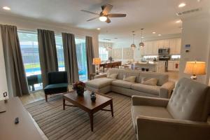 sala de estar con sofá, mesa y cocina en Brand new home at Sonoma Resort at Tapestry en Kissimmee