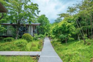 a walkway in front of a house with trees at Hakone Retreat F&ouml;re in Hakone