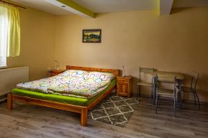 1 dormitorio con 1 cama, 1 mesa y 1 silla en Apartman ViVi Pribylina, en Liptovský Mikuláš