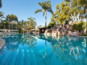 a swimming pool at a resort with palm trees at BlueBay Banús in Marbella