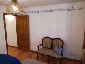 a living room with a chair and blue stenciled wall at Casa Mateus - Colares, Parque Natural Sintra Cascais in Sintra