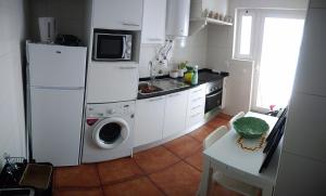 a kitchen with a refrigerator and a washing machine at Casa Mateus - Colares, Parque Natural Sintra Cascais in Sintra