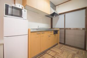 a kitchen with a white refrigerator and a sink at Hokusai Stay in Osaka +23 photos