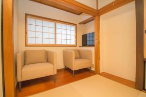 two chairs in a waiting room with a window at Hokusai Stay in Osaka