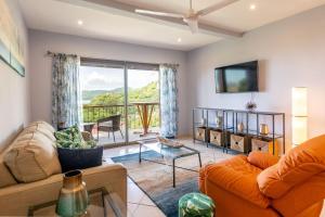 ein Wohnzimmer mit einem Sofa und einem TV in der Unterkunft 2-Bedroom Ocean-View Condo with Pool in Playa Flamingo