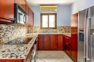 a kitchen with a sink and a refrigerator at 2-Bedroom Ocean-View Condo with Pool in Playa Flamingo