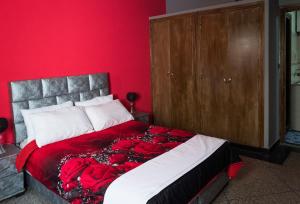 Modern and Cozy Apartment في الدار البيضاء: غرفة نوم حمراء عليها سرير وورد
