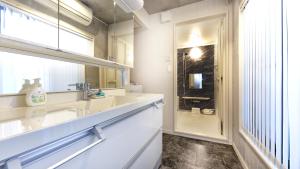 a white bathroom with a sink and a shower at Uhome Otsuka Villa in Tokyo +36 photos