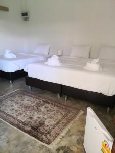 2 Betten in einem Zimmer mit einem Teppich in der Unterkunft Tropical House​ in Hua Hin