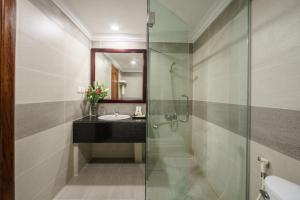 a bathroom with a glass shower and a sink at Smiling Deluxe Hotel in Siem Reap