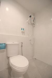 a bathroom with a white toilet and a shower at INTERest POSHTEL in Bangkok