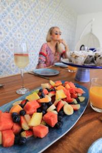 a woman sitting at a table with a plate of fruit at Valle Vista Luxury Apartments in Cairns