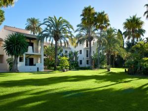 a large yard with palm trees in front of a building at BlueBay Banús in Marbella