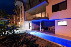 a house with a swimming pool at night at Valle Vista Luxury Apartments in Cairns
