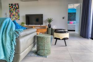 a living room with a couch and a tv at Valle Vista Luxury Apartments in Cairns