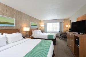 a hotel room with two beds and a flat screen tv at Holiday Inn Express Hotel & Suites Fraser Winter Park Area, an IHG Hotel in Fraser