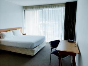 sypialnia z łóżkiem, krzesłem i oknem w obiekcie Picton Yacht Club Hotel w mieście Picton