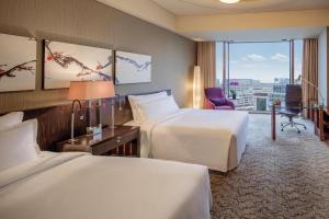 a hotel room with two beds and a desk at Regent Beijing in Beijing