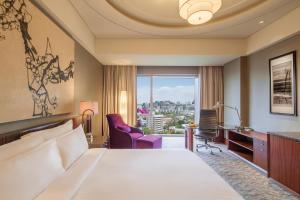 Regent Beijing في بكين: غرفه فندقيه بسرير ونافذه