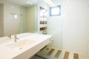 a white bathroom with a sink and a mirror at Fisherman's Resort Haad Chao Samran in Haad Chao Samran