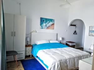 a white bedroom with a bed and a blue rug at Logaras Seaview Apartment in Logaras