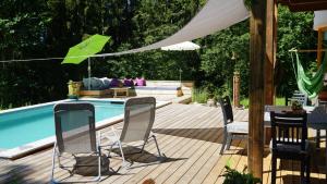 eine Terrasse mit Stühlen neben einem Pool in der Unterkunft AlpenSportChalet in Werfenweng