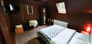 a bedroom with a bed and a table and a television at Vila Coca in Predeal