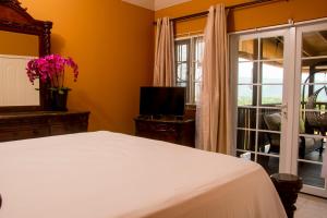 a bedroom with a white bed and a window at Vacation Getaway in Mango Walk Country Club in Montego Bay