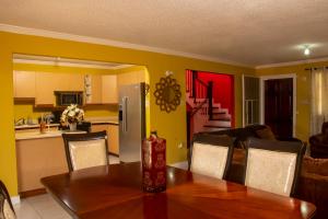 a dining room with a table and a kitchen at Vacation Getaway in Mango Walk Country Club in Montego Bay