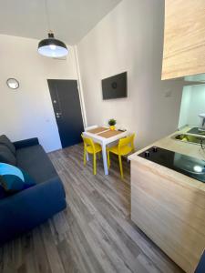 una cucina e un soggiorno con tavolo e sedie gialle di Apartments Flanaticus a Pola (Pula)