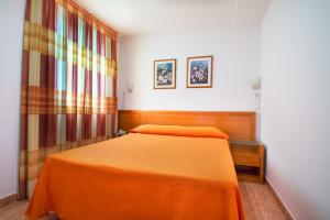 a bedroom with a bed with an orange bedspread at Hotel Mavi in Gandía +30 photos