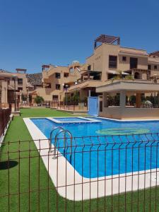 a swimming pool in front of a building at Apartamento María Isabel en Los Collados Golf - Aguilas in Águilas