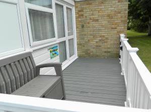 a porch with a bench on a house at Bespoke Chalet 214, walk to the beach & close to Norfolk broads - pet friendly! in Great Yarmouth