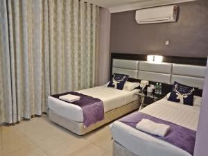 a hotel room with two beds and a table at T Hotel Johor Bahru in Skudai