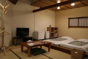 a room with two beds and a tv and a table at Hotel Daiki in Osaka