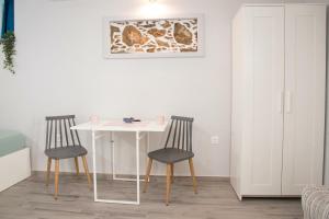 a white table and two chairs in a room at Studio Cozy - In the Heart of Skyros Village in Skiros