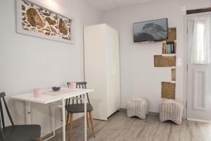 a dining room with a white table and chairs at Studio Cozy - In the Heart of Skyros Village in Skiros