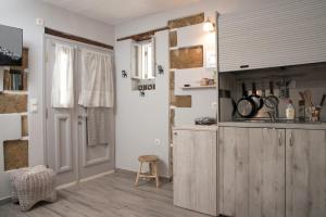 a kitchen with a counter and a stool in a room at Studio Cozy - In the Heart of Skyros Village in Skiros