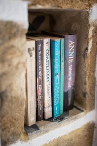 uma fila de livros sentados numa prateleira em Studio Cozy - In the Heart of Skyros Village em Skiros